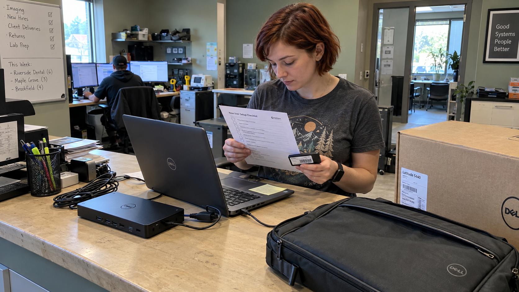 Technician checks a new user laptop, asset tag, and IT onboarding checklist at an MSP delivery counter