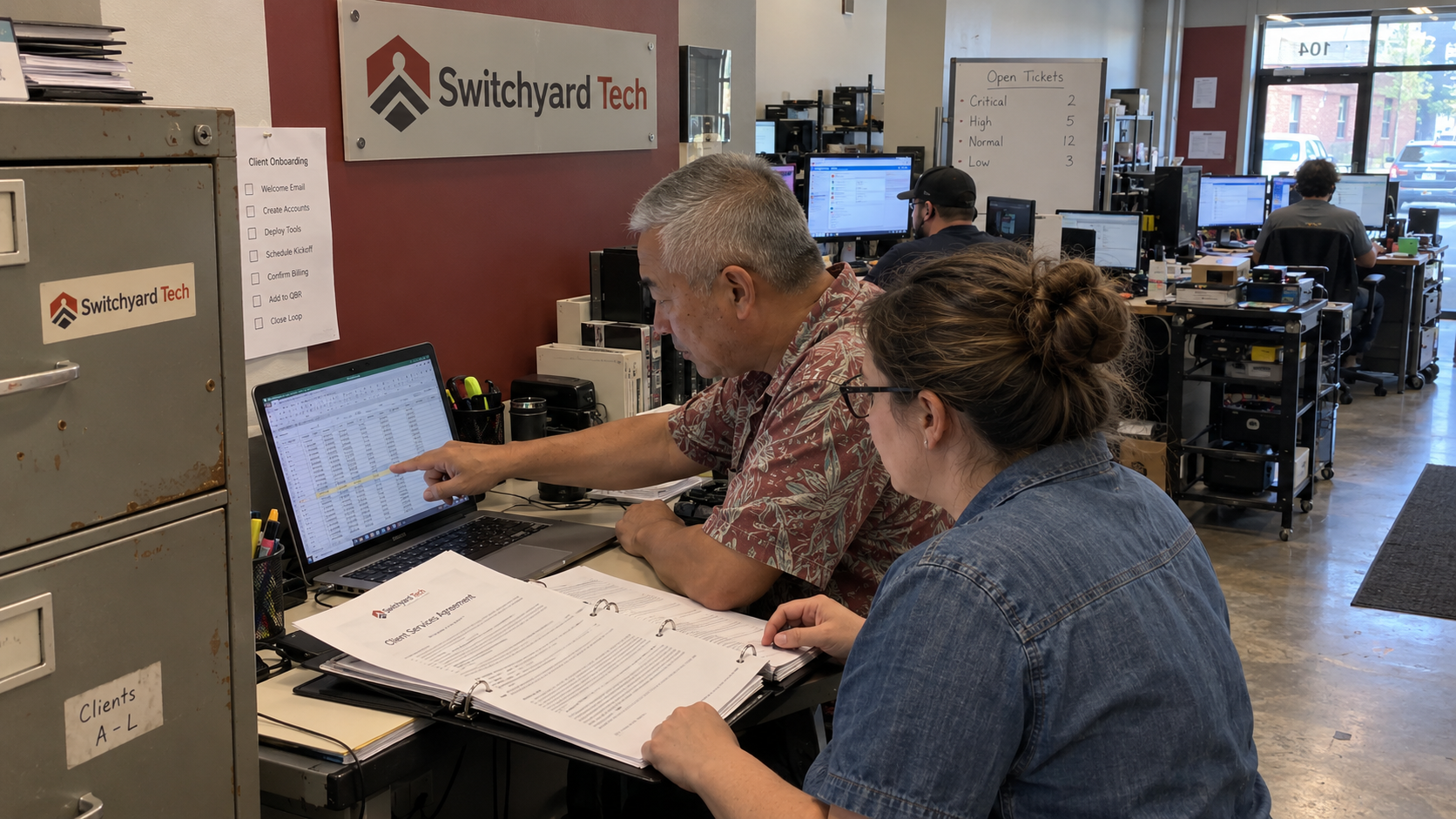 MSP colleagues check a client schedule against contracts for a customer list valuation