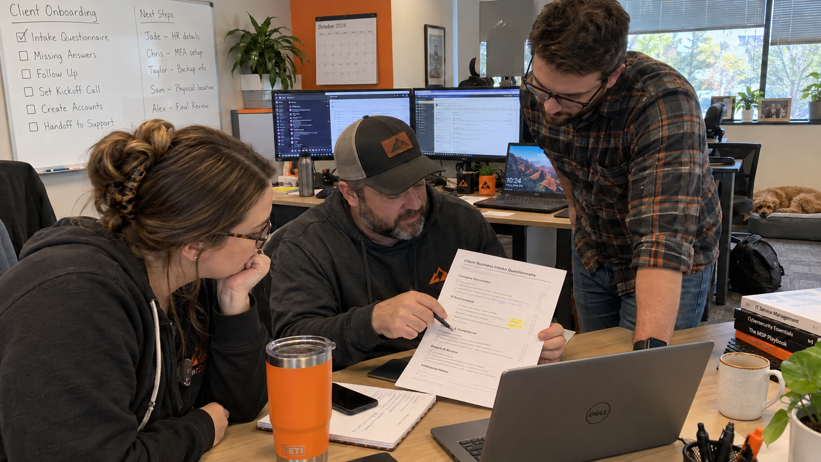 Three coworkers review a client onboarding questionnaire at a desk with a Dell laptop.
