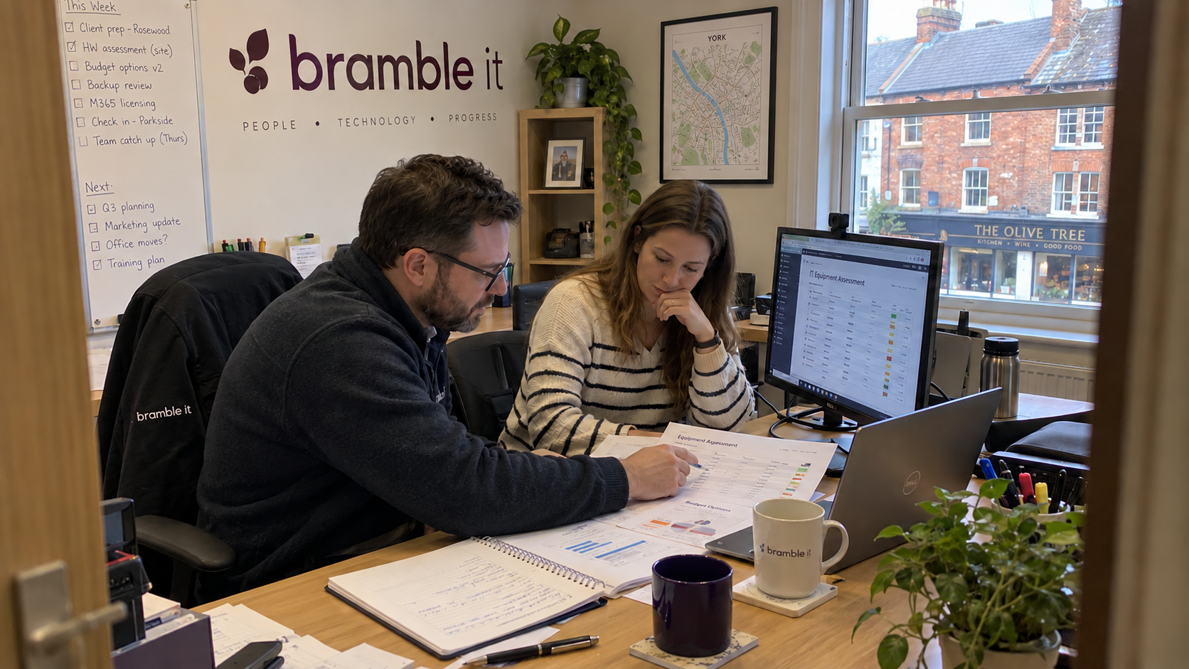 Two MSP colleagues review an equipment assessment and budget plan to clarify TAM vs vCIO responsibilities