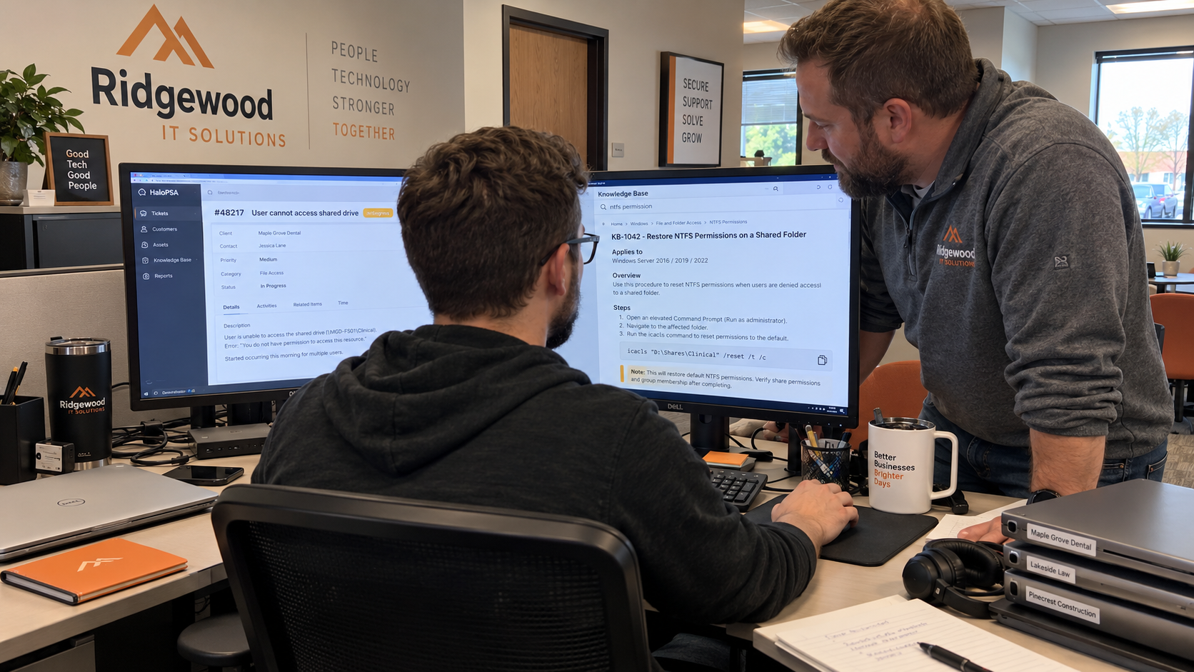 Two MSP colleagues consult a knowledge-base procedure beside an open support ticket