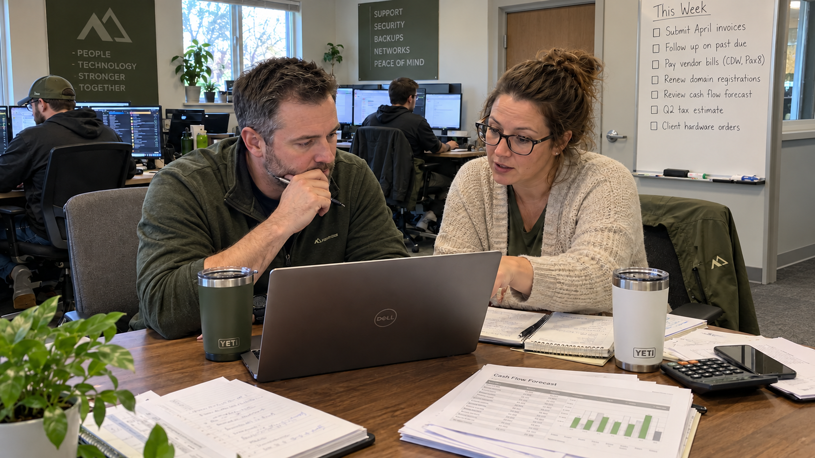 MSP owners review a forecast at their office desk: profitable but no cash flow before bills are due
