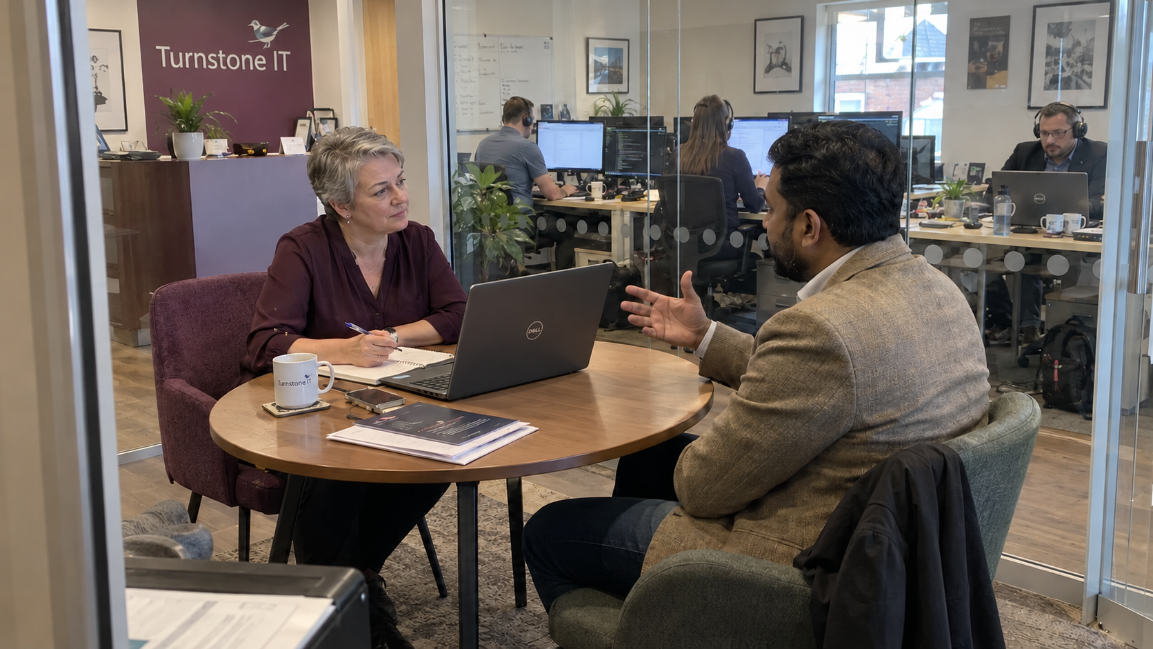 An MSP salesperson interviews a client in the office meeting area to fill in a customer case study template